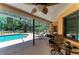 A comfortable covered patio with fan, outdoor furniture and a view of the sparkling in-ground pool at 410 136Th E Ct, Bradenton, FL 34212