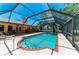 In-ground pool and jacuzzi with screened enclosure offers a private oasis with lush greenery at 410 136Th E Ct, Bradenton, FL 34212