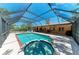 Backyard pool with a screened enclosure, spa, and patio area, perfect for outdoor relaxation and entertainment at 410 136Th E Ct, Bradenton, FL 34212