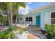 Beautiful home exterior with a front porch, tropical plants, and bright blue door at 410 Garfield Dr, Sarasota, FL 34236