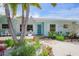 Landscaped home exterior featuring a blue door, beachy foliage, and a cozy porch at 410 Garfield Dr, Sarasota, FL 34236