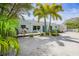 Charming single-story home with a welcoming porch and tropical landscaping at 410 Garfield Dr, Sarasota, FL 34236