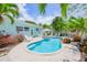 Inviting backyard pool with white Adirondack chairs and tropical landscaping in a lush setting at 410 Garfield Dr, Sarasota, FL 34236