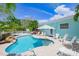 A beautiful pool with an umbrella and lounge chairs, perfect for relaxing in the sun at 410 Garfield Dr, Sarasota, FL 34236