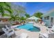 Inviting pool area, perfect for relaxation, with tropical greenery and white furniture at 410 Garfield Dr, Sarasota, FL 34236
