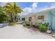 Well-maintained home exterior with lush landscaping and a bright blue facade at 410 Garfield Dr, Sarasota, FL 34236