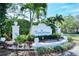 Entrance to Plaza de Flores featuring lush landscaping and a decorative community sign at 4264 Central Sarasota Pkwy # 111, Sarasota, FL 34238