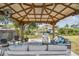 Inviting backyard patio features comfortable seating, an overhead covering, and relaxing canal views at 4309 Pinfish Ln, Palmetto, FL 34221