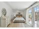 Bright bedroom with light hardwood floors and double doors to the outside at 4309 Pinfish Ln, Palmetto, FL 34221