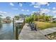 Wooden dock with boat lift and lounge chairs offers direct access to the calm waterway at 4309 Pinfish Ln, Palmetto, FL 34221