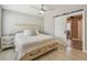 Calm main bedroom with neutral colors, wood floors, barn door leading to ensuite bathroom, and ceiling fan at 4309 Pinfish Ln, Palmetto, FL 34221