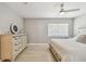 Bedroom with white ceiling fan, lots of light, light wood floors, and dresser with decor accents at 4309 Pinfish Ln, Palmetto, FL 34221