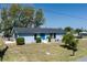 Classic one-story light blue home featuring a blue door, neat landscaping, and a well-kept lawn at 4403 5Th W Ave, Palmetto, FL 34221