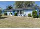 Charming blue home featuring a bright blue door, modern windows, and a well-maintained front lawn at 4403 5Th W Ave, Palmetto, FL 34221