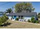 Lovely one-story blue house featuring a bright blue door, modern windows, and manicured landscaping at 4403 5Th W Ave, Palmetto, FL 34221