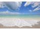 Scenic beach with clear, shallow turquoise water, white sand, and gentle waves, perfect for a relaxing day by the sea at 501 Key Royale Dr, Holmes Beach, FL 34217