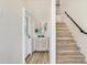 Bright entryway featuring wood-look floors, stairs, a cabinet, and decor at 501 Key Royale Dr, Holmes Beach, FL 34217