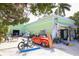 Charming green building with a classic red car, bicycles, and unique decorative items at 501 Key Royale Dr, Holmes Beach, FL 34217