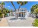 Bright waterfront home with gravel landscaping, covered parking, and staircase leading to the second-floor deck at 501 Key Royale Dr, Holmes Beach, FL 34217