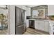 Bright kitchen with stainless steel refrigerator, white cabinetry, and a window view at 501 Key Royale Dr, Holmes Beach, FL 34217