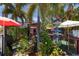Charming outdoor dining area with lush foliage and colorful umbrellas for shade at 501 Key Royale Dr, Holmes Beach, FL 34217