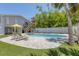 Poolside retreat featuring lounge chairs, landscaping, a yellow umbrella, and an elevated home with a covered parking area at 501 Key Royale Dr, Holmes Beach, FL 34217