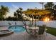 Outdoor dining table, patio umbrella, pool and jacuzzi with pavers and string lights at 501 Key Royale Dr, Holmes Beach, FL 34217