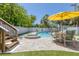 Backyard pool featuring a jacuzzi, outdoor seating, and privacy fence with lush tropical landscaping and artificial grass at 501 Key Royale Dr, Holmes Beach, FL 34217