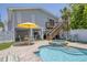 Backyard pool with a jacuzzi, open-air garage, and steps to the home's deck, surrounded by a well-manicured outdoor space at 501 Key Royale Dr, Holmes Beach, FL 34217