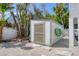 Outdoor shed with space for kayaks and paddleboards and exterior lighting, set against a backdrop of lush tropical greenery at 501 Key Royale Dr, Holmes Beach, FL 34217
