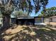 View of screened lanai and fenced backyard with mature trees at 5030 Lahaina Dr, Sarasota, FL 34232