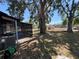 Home's shady backyard featuring a screened-in porch at 5030 Lahaina Dr, Sarasota, FL 34232