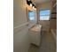 Bright bathroom featuring a single sink vanity, framed mirror, and tile flooring at 5030 Lahaina Dr, Sarasota, FL 34232