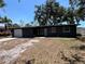 Charming single-story home showcasing a dark gray exterior, a two-car garage and mature trees in the front yard at 5030 Lahaina Dr, Sarasota, FL 34232