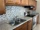 Updated kitchen featuring a stainless steel stove and a mosaic tile backsplash at 5030 Lahaina Dr, Sarasota, FL 34232