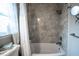 Modern tub and shower with tiled walls and neutral-colored fixtures at 512 Shamrock Blvd, Venice, FL 34293
