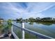 Calm waterfront view from a dock, enhanced by a metal railing and lush potted plants at 512 Shamrock Blvd, Venice, FL 34293