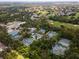 Overhead shot of meticulously kept tennis courts enveloped by abundant, mature trees at 5336 Huntingwood Ct # 24, Sarasota, FL 34235