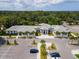 Aerial view of a modern commercial building featuring ample parking, surrounded by lush trees and greenery at 5336 Huntingwood Ct # 24, Sarasota, FL 34235