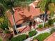 Aerial view of a charming villa with a private courtyard, lush landscaping, and a tile roof at 5336 Huntingwood Ct # 24, Sarasota, FL 34235