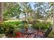 Outdoor patio space surrounded by mature trees and landscaping at 5336 Huntingwood Ct # 24, Sarasota, FL 34235