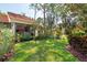 Backyard featuring a well-manicured lawn, mulched flowerbeds, and mature trees for enhanced privacy at 5336 Huntingwood Ct # 24, Sarasota, FL 34235
