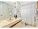 Cozy bathroom with floral wallpaper, a vanity with a white sink, white tile flooring, and a shower with a curtain at 5336 Huntingwood Ct # 24, Sarasota, FL 34235