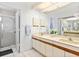 Bathroom with double sink vanity, large mirror, and walk-in shower at 5336 Huntingwood Ct # 24, Sarasota, FL 34235