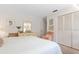 Bedroom features a bed with white quilted cover, neutral walls, and a mirrored dresser with a comfortable armchair at 5336 Huntingwood Ct # 24, Sarasota, FL 34235
