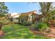 Home exterior with a well-kept lawn, garden beds, and mature trees providing lots of shade at 5336 Huntingwood Ct # 24, Sarasota, FL 34235