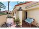Charming front patio with brick flooring, cozy seating, and lush potted flowers at 5336 Huntingwood Ct # 24, Sarasota, FL 34235