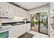 Bright kitchen featuring white cabinets, black countertops, and sliding doors to the lanai at 5336 Huntingwood Ct # 24, Sarasota, FL 34235