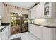 Bright kitchen featuring white cabinets, black countertops, tile floors, and sliding glass doors to a patio at 5336 Huntingwood Ct # 24, Sarasota, FL 34235