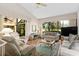 Spacious living room featuring vaulted ceilings, large windows, and hardwood floors with seating and a ceiling fan at 5336 Huntingwood Ct # 24, Sarasota, FL 34235